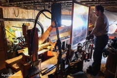 Hector Chaloux operating the wood processor that cuts logs into cord wood and then splits it and moves it by conveyor belt to a dump truck.