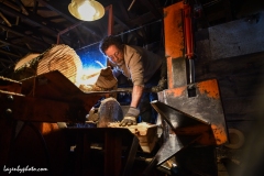 Hector Chaloux holding cord wood to be split in the wood processor.